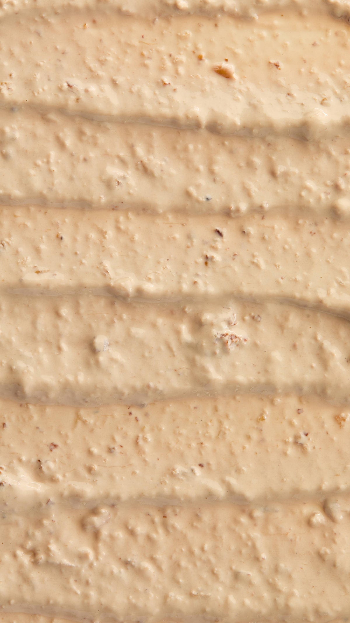 A super close-up image of the creamy, textured Bring Us Some Figgy Pudding face mask product, focusing on the consistency and flecks of finely blended dried figs throughout.