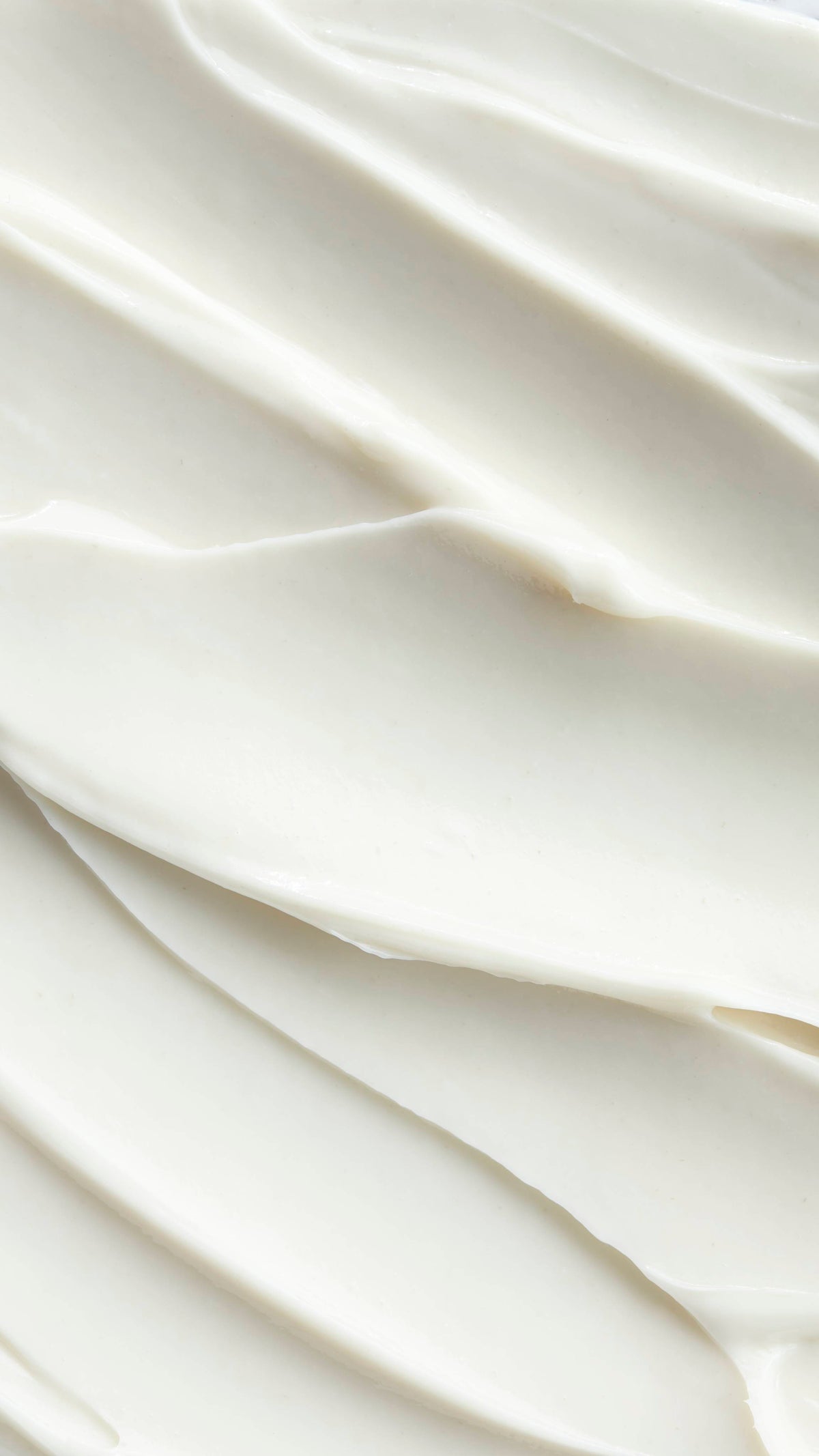 A detailed, close-up shot of Super Milk conditioner with soft, swooping peaks and valleys. The texture appears rich and luxurious, inviting the viewer to touch it.