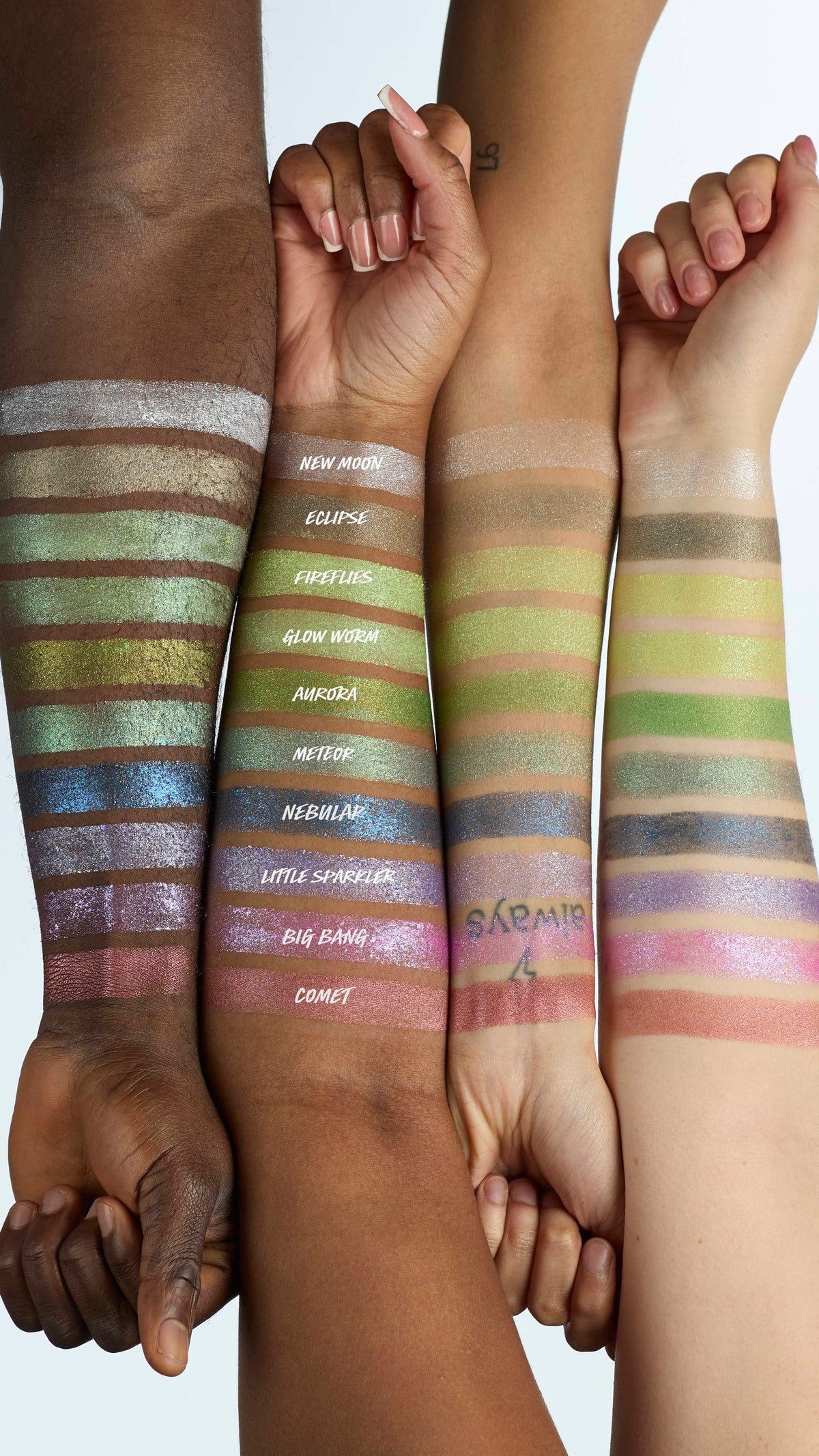 The image shows four model's forearms laid next to each other in varying shades of skin colour. There is a line of ten Glitter Crumble swatches across all four arms to showcase how each product colour shows up on different skin tones.
